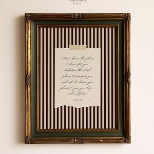 May include: A framed print with a gold and green ornate frame. The print features a torn piece of paper with handwritten text, adhered with tape, against a background of vertical black and white stripes. The text reads "For I know the plans I have for you..."