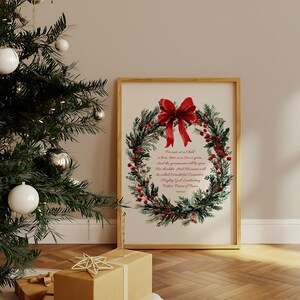 May include: A framed print featuring a watercolor wreath with red berries and a large red bow. The wreath surrounds text from Isaiah 9:6. A Christmas tree with ornaments and wrapped gifts are in the foreground.