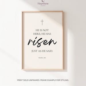 May include: Framed print with a cream background and black text. The text reads "HE IS NOT HERE; HE HAS risen JUST AS HE SAID." A cross is at the top. The text "Matthew 28:6" is at the bottom.