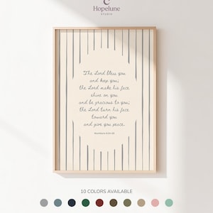 May include: A rectangular wall art print in a light wood frame featuring a cream background with vertical grey stripes. The center displays the text: The Lord bless you and keep you; the Lord make his face shine on you and be gracious to you; the Lord turn his face toward you and give you peace. Numbers 6:24-26.