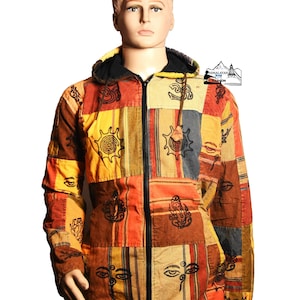 Pode incluir: Casaco patchwork com capuz em tons de laranja, amarelo e castanho. O casaco, com fecho de correr, é adornado com vários símbolos espirituais. A peça de vestuário é exibida num manequim e é feita de várias aplicações de tecido.