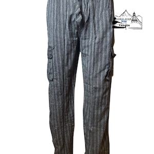 Könnte beinhalten: Grau-weiß gestreifte Cargohose mit Kordelzug in der Taille. Die Hose hat zwei Cargotaschen an den Seiten und eine lockere Passform. Das Logo "Himalayan Soul Fashion" ist oben rechts sichtbar.