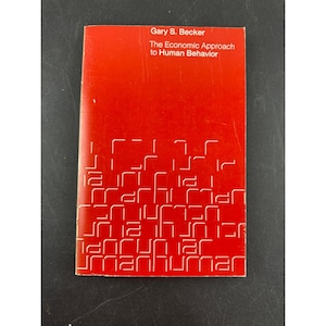 May include: A red paperback book titled The Economic Approach to Human Behavior by Gary S. Becker. The cover features white text at the top and a repeating, stylized white geometric pattern across the bottom half of the front cover.
