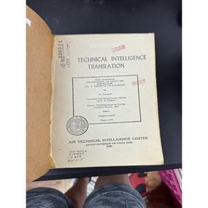 Può includere: Un libro aperto intitolato "Technical Intelligence Translation" con testo in inglese. La copertina del libro è bianco sporco con testo nero. Il libro proviene dall'Air Technical Intelligence Center, Wright-Patterson Air Force Base, Ohio.