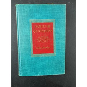 Könnte beinhalten: Eine weiße Keramik-Tasse mit schwarzem Henkel und dem Text "But First, Coffee" in fetter, schwarzer Schrift. Die Tasse steht vor einem verschwommenen Hintergrund, der eine gemütliche Umgebung suggeriert.