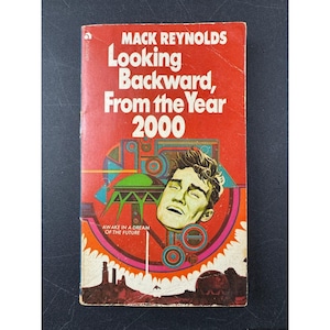 May include: A retro paperback book cover for "Looking Backward, From the Year 2000" by Mack Reynolds. The cover is red with a vintage illustration of a man's face and futuristic elements. The text "AWAKE IN A DREAM OF THE FUTURE" is also visible.