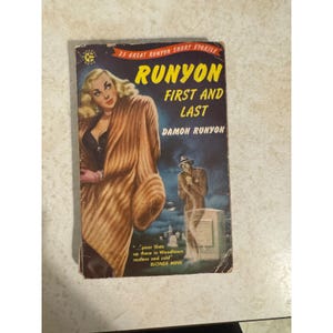 May include: A vintage paperback book, "Runyon First and Last" by Damon Runyon. The cover shows a blonde woman in a fur coat and a man in a suit near a tombstone. The book is from the 1950s and has a worn appearance.