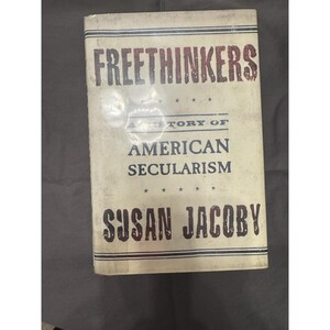 May include: A vintage book titled "FREETINKERS" with the subtitle "A History of American Secularism" by Susan Jacoby. The cover is off-white with dark red and black text. The book has a worn appearance.
