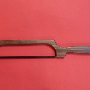 May include: A wooden-handled saw with a black blade. The handle is made of dark wood and has a decorative loop at the end.