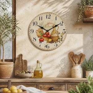 Peut inclure: Une horloge murale ronde au cadran crème avec des chiffres arabes noirs et une illustration centrale représentant une cruche en céramique, des tomates rouges, une burette à huile en verre et des olives. Deux aiguilles noires et un bord pointillé.