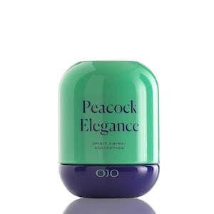 May include: A cylindrical product with a rounded top and bottom. The top is a glossy green, and the bottom is a deep blue. The text "Peacock Elegance" is printed on the green section, with "SPIRIT ANIMAL COLLECTION" below it.