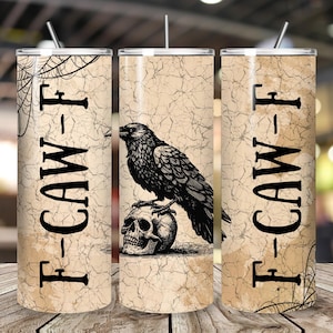 May include: Three stainless steel tumblers with lids and straws. The tumblers feature a vintage design with a raven perched on a skull. The text "F-CAW-F" is printed vertically on the side. A spiderweb design is on the side of two tumblers.