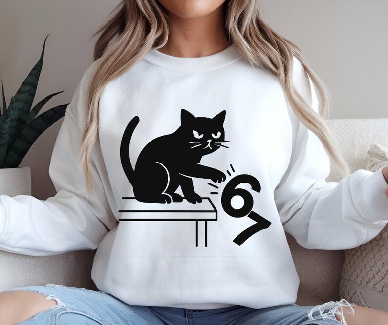 Pu&ograve; includere: Felpa bianca con un disegno di gatto nero. Il gatto &egrave; raffigurato mentre rovescia i numeri 6 e 7. Il gatto ha un'espressione arrabbiata. La felpa &egrave; in stile casual.