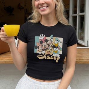 Pu&ograve; includere: Una tazza di ceramica bianca con manico nero e la scritta "But First, Coffee" in grassetto nero. La tazza &egrave; posta su uno sfondo sfocato, che suggerisce un'atmosfera accogliente. La tazza &egrave; alta circa 10 cm.