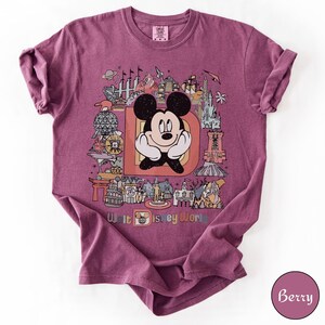 Puede incluir: Camiseta color bayas con un gr&aacute;fico colorido de Mickey Mouse dentro de una gran letra "D" con varios monumentos de Disney World. Las palabras "Walt Disney World" est&aacute;n impresas en la parte inferior. La camiseta tiene cuello redondo y mangas cortas.