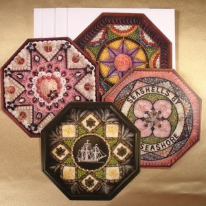 May include: Four octagonal framed pieces of art made from seashells. Each piece features a different design, including a star, a flower, and a ship. The frames are dark brown and the shells are in shades of pink, white, and brown.