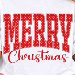 May include: A white short-sleeved t-shirt featuring the text Merry Christmas in red. The word Merry is written in a large, blocky, red font with white polka dots, while the word Christmas is written below in a smaller, red, cursive script font.