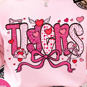 May include: Pink sweatshirt with a graphic design that says "Thanks" in a pink glittery font. The word "Thanks" is decorated with hearts, wings, and a bow. The design also includes the text "Design Pink Art" and "PNG DIGITAL DOWNLOAD".
