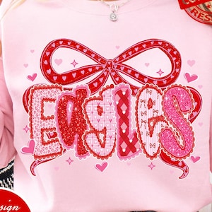 Può includere: Una felpa rosa chiaro con la scritta "EASIES" in un carattere decorativo, con un fiocco rosso e dettagli a forma di cuore. Il design include il testo "PNG | DIGITAL DOWNLOAD".