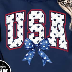 Puede incluir: Sudadera azul marino con la palabra "USA" en blanco, llena de un patrón de estrellas y un contorno rojo. Un lazo azul con estrellas blancas está debajo del texto. El diseño incluye un logotipo de "Design Pink Art" y el texto "PNG | DIGITAL DOWNLOAD".
