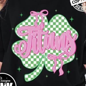 May include: Black t-shirt featuring a pink and green clover design with the word "Titans" in a cursive font. The clover has a checkered pattern and pink bows. The design includes the text "PNG | DIGITAL DOWNLOAD".