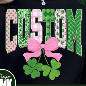 May include: Black sweatshirt with the word "CUSTOM" in green and pink patterns, a pink bow, and green shamrocks. The design includes the text "PNG | DIGITAL DOWNLOAD" and a "Design PINK Art" logo.