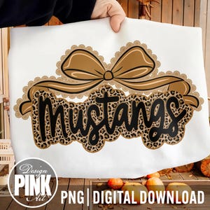 May include: White fabric with a brown bow and the word "Mustangs" in black leopard print. The design includes a scalloped border and the text "Design PINK Art" and "PNG | DIGITAL DOWNLOAD".