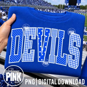 May include: A royal blue crewneck sweatshirt featuring the word DEVILS in large, white block letters. Each letter has a unique pattern, including polka dots, gingham checks, and vertical stripes. The design is printed on the front of the garment.