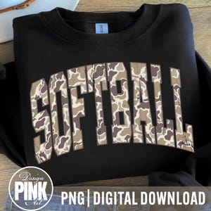 May include: Black sweatshirt with the word "SOFTBALL" in large, distressed camouflage lettering across the front. The sweatshirt has a crew neck and long sleeves. The image also includes a "Design Pink Art" logo and text that reads "PNG | DIGITAL DOWNLOAD".