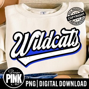 Peut inclure: Sweat-shirt crème avec le mot "Wildcats" en blanc, souligné de bleu et de noir, avec un effet vieilli. Le design comprend un tampon de copyright et le texte "PNG | DIGITAL DOWNLOAD".