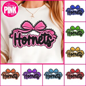 May include: White sweatshirt with a pink bow and the word "Hornets" in a black, pink, and white design. The image also shows variations of the design in blue, green, yellow, orange, purple, and red.