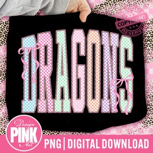 Puede incluir: Camiseta negra con la palabra "DRAGONS" en letras grandes y coloridas a cuadros. Las letras están delineadas en blanco y tienen lazos rosas. El diseño incluye el texto "Design PINK Art" y "PNG | DIGITAL DOWNLOAD".