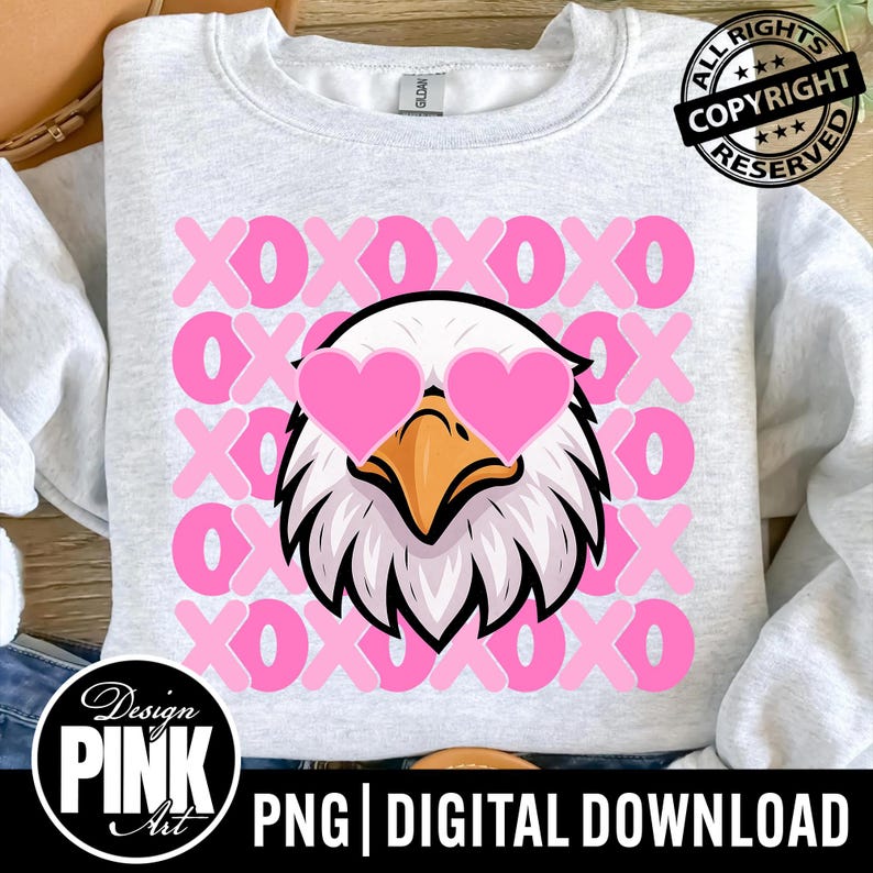 K&ouml;nnte beinhalten: Ein hellgraues Sweatshirt mit einer Grafik eines Adlers, der eine rosa herzf&ouml;rmige Sonnenbrille tr&auml;gt. Der Hintergrund hat ein Muster aus rosa "XOXO"-Buchstaben. Das Design enth&auml;lt den Text "Design PINK Art" und "PNG | DIGITAL DOWNLOAD".