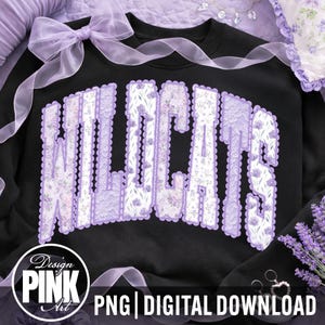 May include: Black sweatshirt with the word "WILDCATS" in large, lavender-colored, floral-patterned letters. The letters have a scalloped edge. A lavender bow and ribbon are at the top. The bottom of the image has the text "PNG | DIGITAL DOWNLOAD".