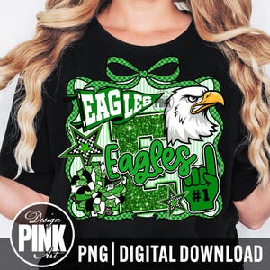 May include: Black t-shirt with a green and white Eagles graphic. The design includes an eagle head, stars, and the word "Eagles" in a bold font. The design also includes a green bow and the number one.
