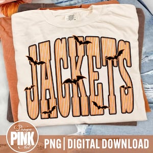 May include: A cream-colored t-shirt featuring the word JACKETS in large, bold, orange and white vertical striped letters with a black outline. Several small black bat silhouettes are scattered across and around the lettering.