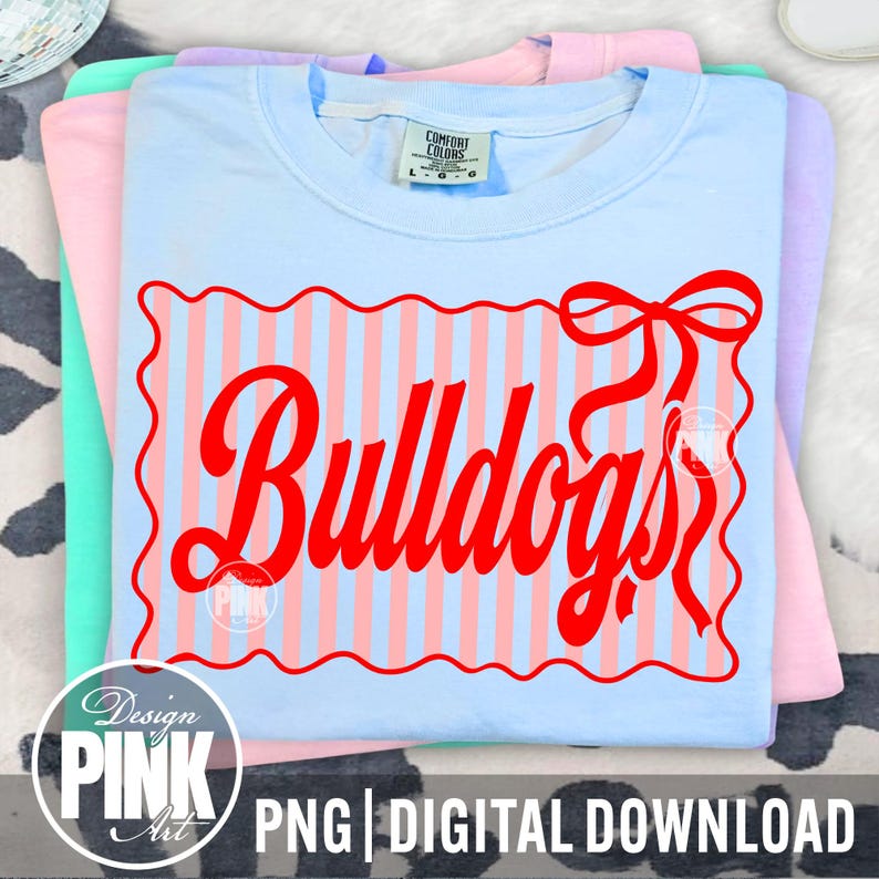 May include: A stack of pastel-colored t-shirts. The top shirt is light blue with a red design that says "Bulldogs" in a decorative font. The design is framed by a wavy red border and vertical pink and blue stripes. The text "PNG | DIGITAL DOWNLOAD" is at the bottom.