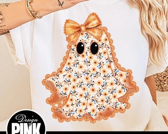 May include: White t-shirt featuring a ghost design. The ghost is adorned with a floral pattern in shades of orange, yellow, and blue, with a matching bow and lace trim. The design includes large black eyes. The image also includes the text "Design Pink Art" and "PNG | DIGITAL DOWNLOAD".