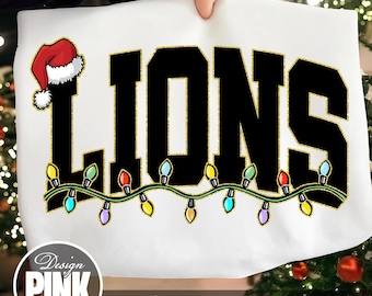 May include: White sweatshirt featuring the word "LIONS" in large black letters with gold glitter edging. A Santa hat adorns the letter "L". Below, a string of colourful Christmas lights. The text "PNG | DIGITAL DOWNLOAD" is at the bottom.
