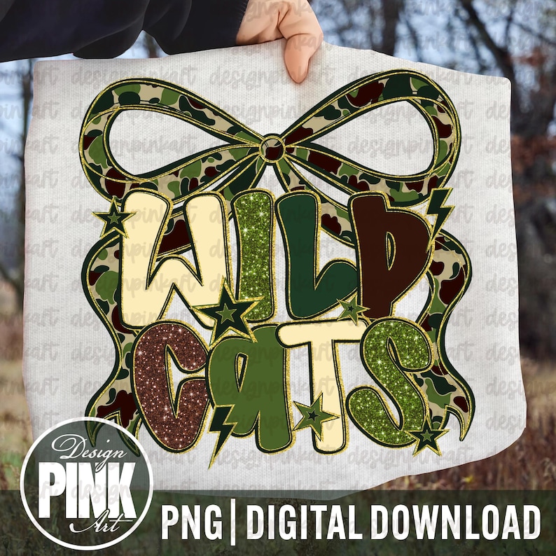 May include: A white background with the words "WILD CATS" in a decorative font, with a camouflage bow and stars. The text is in shades of green, brown, and gold. The image also includes the text "PNG | DIGITAL DOWNLOAD" and a logo for "Design PINK Art".