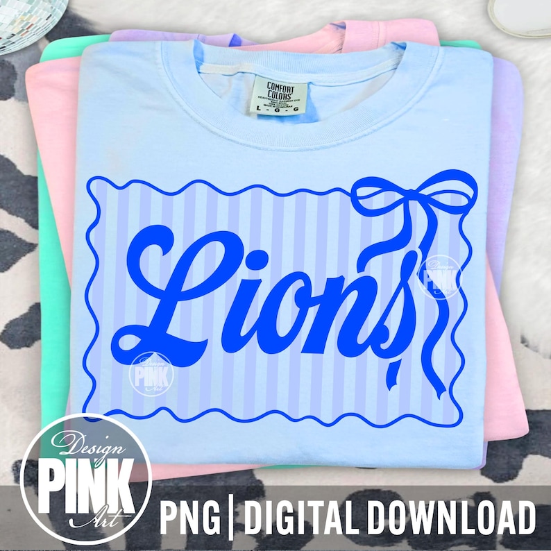 May include: A stack of pastel-colored t-shirts. The top shirt is light blue with a blue design that says "Lions" in a script font, with a bow and striped background. The bottom of the image has the text "PNG | DIGITAL DOWNLOAD".