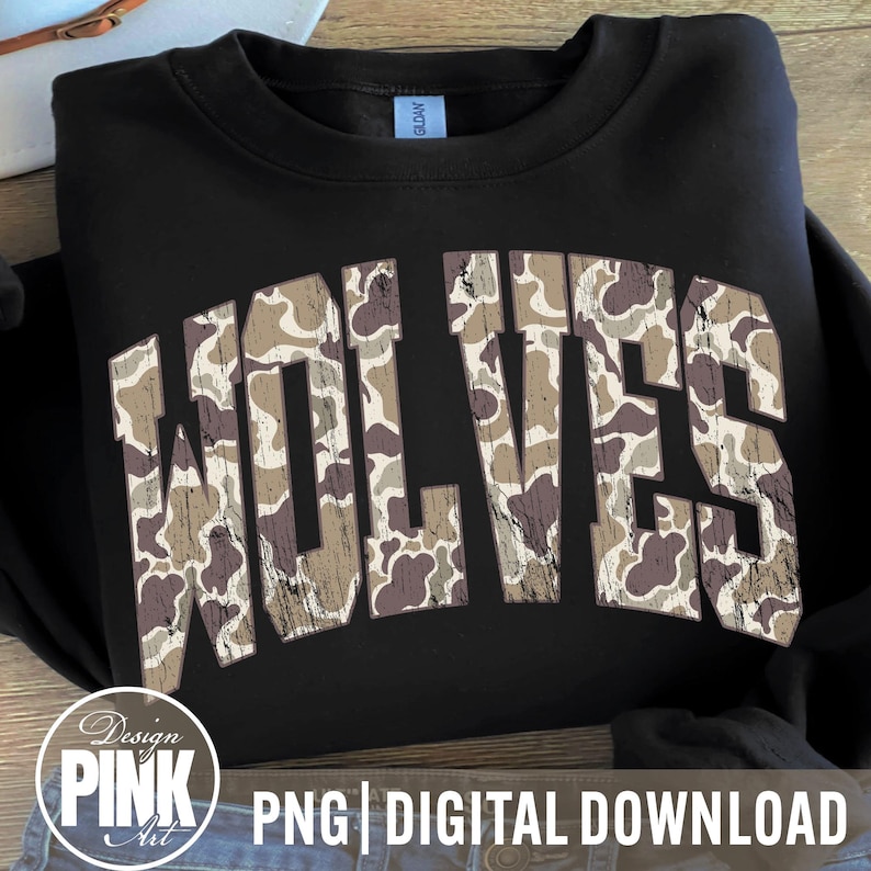 May include: Black sweatshirt with the word "WOLVES" in large, distressed, camouflage-patterned letters across the front. The sweatshirt is folded, and the design is centered. The words "PNG | DIGITAL DOWNLOAD" are at the bottom.