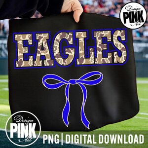 May include: Black tote bag with the word "EAGLES" in camouflage print with a blue outline. A blue bow is below the word. The words "PNG | DIGITAL DOWNLOAD" are at the bottom. The Design Pink Art logo is in the upper right and lower left corners.
