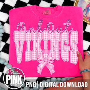 Op de afbeelding: Een felroze T-shirt met korte mouwen met de tekst Pink Out in een cursief lettertype boven het woord VIKINGS in een wit en roze gingham-patroon. Een roze bewustzijnslintje staat gecentreerd onder de tekst op de voorkant van het T-shirt.