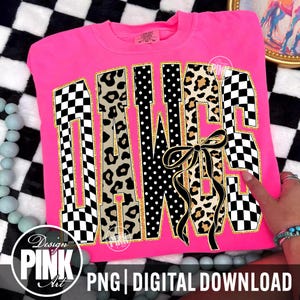 May include: A bright pink sweatshirt with the word "DAWGS" in a bold, decorative font. The letters feature a mix of patterns, including checkered, leopard print, and polka dots, with gold trim. A black bow is centered below the letters.