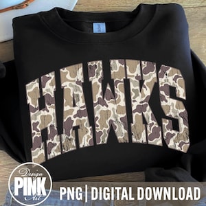 May include: Black crewneck sweatshirt with the word "HAWKS" in a camouflage pattern across the front. The sweatshirt has a classic fit and is made of a soft material. The design is a digital download.