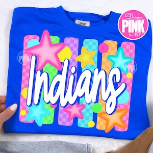 May include: A royal blue crew neck sweatshirt with the word "Indians" in white script. The design includes colorful stars and vertical stripes in pink, green, orange, and purple. The shirt has a "Design PINK Art" logo.