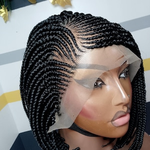 May include: A black braided wig in a bob style. The wig has a lace front and is styled with neat, individual braids. The braids are tightly woven, creating a textured surface. The wig is designed to mimic a natural hairline.