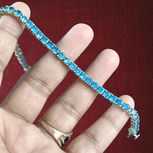 Pulsera de tenis con topacio azul sintético de talla redonda y acabado en oro blanco de 14 quilates, plata de ley 925, 19 cm (7,5 pulgadas). Ideal para regalar.