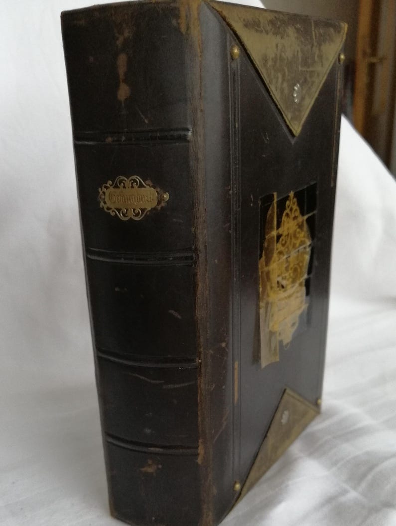 May include: A dark brown leather-bound book with gold accents. The book has a decorative gold label that reads "Columbia". The cover features a gold-colored flap and corner protectors.